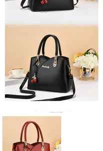 Close-up of elegant faux leather handbags with gold logo and cherry charm detail