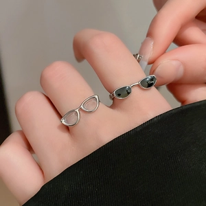 Close-up of creative Y2K eyewear rings in silver and black on hand with a modern style