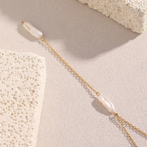 Detailed close-up of 18K gold plated chain with two elegant white baroque pearls