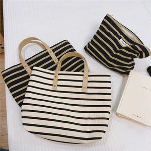 Detail of striped canvas tote bags and pouch with premium leather handles and rivets