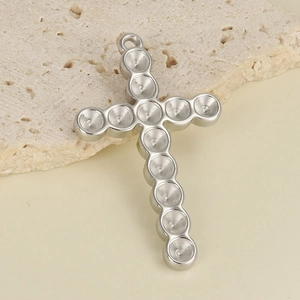 Macro shot of silver 304 stainless steel cross pendant with circular settings for DIY jewelry