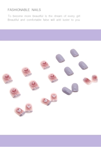 Detail view of purple and heart-patterned short square press-on nails on a clean background