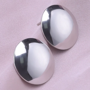 Macro shot of polished oval 304 stainless steel stud earrings on pink satin fabric