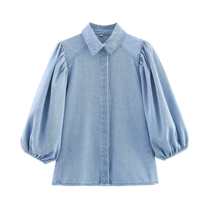 Détail d'une chemise en jean bleu clair avec manches bouffantes et col polo classique