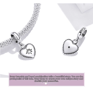 Macro view of S925 sterling silver heart charm with starburst zircon and mesh bracelet