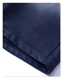 Dettaglio ravvicinato della trama in maglia blu scuro e delle cuciture sull'orlo di un completo