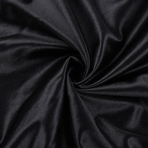 Vue macro du tissu noir lisse d'une robe de soirée avec drapé élégant et fini soyeux