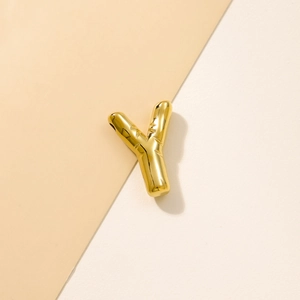 Close-up of a chunky golden metal letter Y bubble pendant for DIY jewelry making
