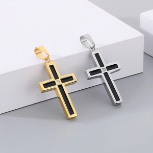 Macro detail of gold and silver cross pendants with black inlay and central crystal
