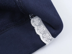 Gros plan du sweat-shirt bleu marine avec détails de dentelle blanche délicate