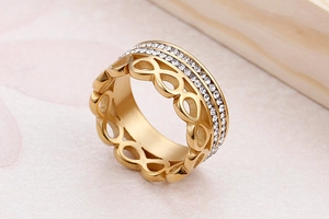 Close-up of golden infinity symbol ring with double rows of sparkling white rhinestones