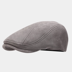 Dettaglio della texture in pelle scamosciata grigio scuro e cuciture sulla coppola