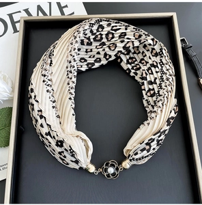 Detail of leopard print pleated scarf necklace with floral magnetic buckle on display