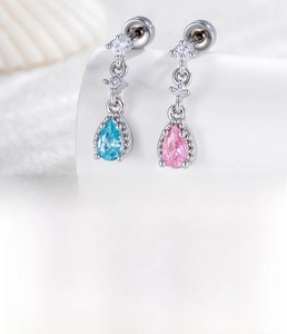 Macro shot of silver teardrop zircon stud earrings with blue and pink crystals