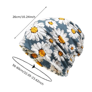 Dark blue slouchy beanie with white daisy prints and size chart measurements
