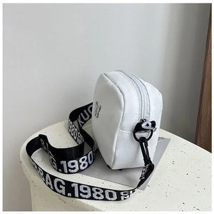 Nylon crossbody bag detail with lettered wide strap and metal butterfly charm