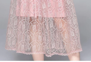Vue détaillée de la dentelle brodée rose et du tulle multicouche sur l'ourlet de la robe
