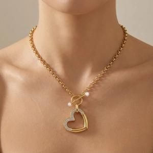 Détail d'un collier pendentif cœur doré avec strass, perles et un fermoir à bascule