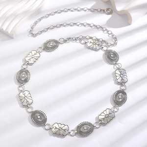 Detail of vintage silver boho waist chain with carved oval and petal metal plates