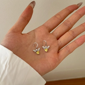Detail of S925 silver bee earrings with yellow heart zircon and white micro-pave stones