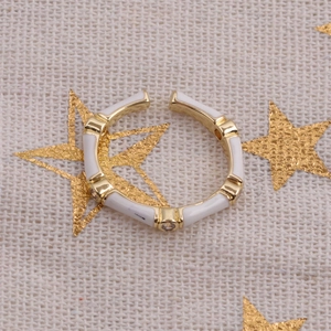 Detailed macro view of bamboo style adjustable ring with white enamel and zircon