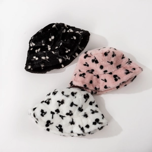 Detailed view of plush faux fur bucket hats with cherry print patterns in various colors