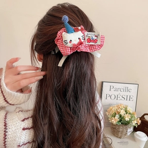 Detailed back view of a red plaid bow hair claw with a plush cartoon kitty character