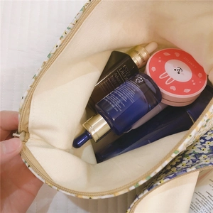 Floral canvas makeup bag showing interior capacity and blue and yellow floral pattern