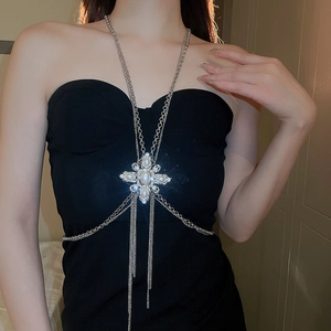 Detail of silver body chain with pearl cross and sparkling rhinestone tassels on model