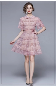 Detail of pink lace layered dress featuring ruffles and elegant fitted waistline