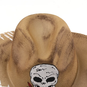 Close-up of distressed cowboy hat with skull print and vintage stained texture