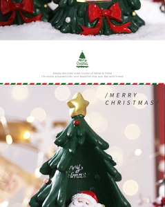 Detail of Christmas tree ornament featuring a small Santa figure and golden star topper