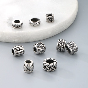 Detailed close-up of patterned titanium steel cylinder spacer beads for bracelets