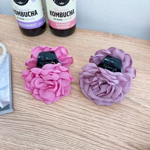 Detail view of large rose hair claws in dark pink and smoky purple organza fabric