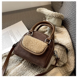 Detail of faux shearling trim and dark brown suede material on the small handbag