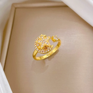 Minimalist gold star and moon open ring with sparkling zircon stones on silk background