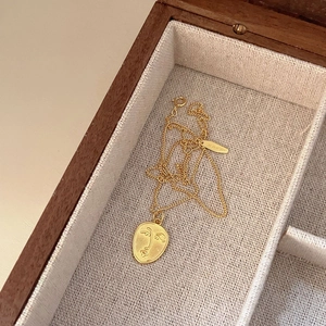 Detailed view of an oval 925 silver face necklace in a premium wooden jewelry box