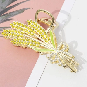 Detail of wheat stalk hair claw with golden rhinestones and green enamel leaves