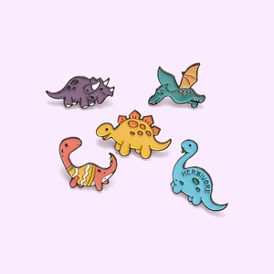 Set of five colorful cartoon dinosaur enamel pins featuring various cute herbivore designs
