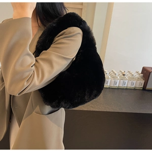 Gros plan du sac à main en peluche noire dans un décor d'intérieur de mode minimaliste