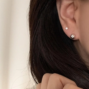 Close-up of minimalist 925 sterling silver ball stud earrings on model's ear