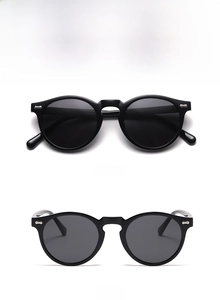 Detailansicht der runden schwarzen matten Sonnenbrille mit Nieten und grauen Gläsern