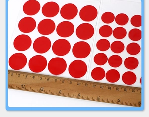 Macro detail of 1cm transparent acrylic round adhesive dots measured by a ruler
