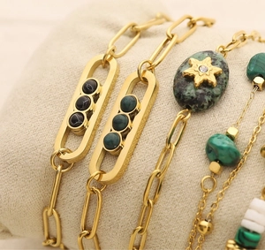 Macro shot of gold-plated bracelets featuring black agate, turquoise and sliding stones