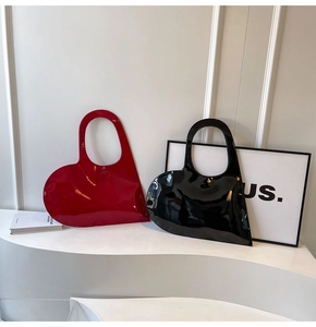 Close-up of heart-shaped glossy patent leather handbags in classic red and black colors