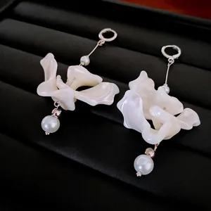 Boucles d'oreilles fleurs et perles avec pétales en résine dans une boîte à bijoux noire
