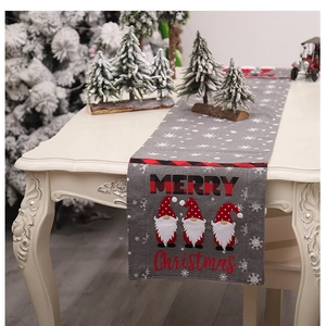 Detail of gray Christmas table runner with gnome embroidery and red plaid borders