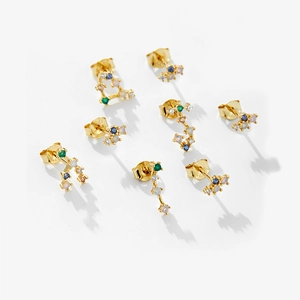 Macro detail of gold S925 silver stud earrings set with colorful opal stones