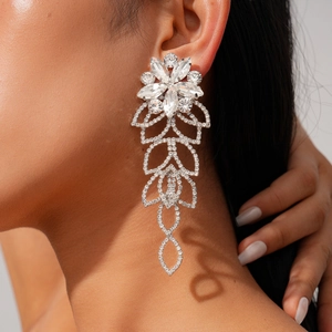 Close-up of silver long tassel earrings with sparkling rhinestones in floral design