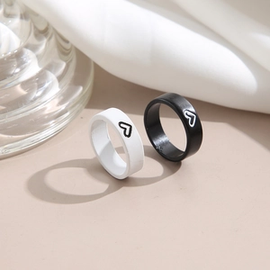 Minimalist black and white heart couple rings set on elegant silk background